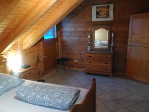 a bedroom in a log cabin with a bed and a mirror at Ferienwohnung Bermbach in Weilburg