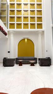 un vestíbulo con sofás y mesas en un edificio en Pride Resort, Rajkot, en Rajkot