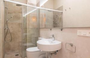 La salle de bains est pourvue de toilettes, d'un lavabo et d'une douche. dans l'établissement HT Inn Centrum Apartments, à Szczecin