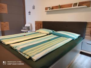 ein Bett mit einer gestreiften Decke darüber in der Unterkunft Ferienwohnung Klein und Fein in Hemfurth-Edersee