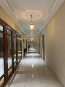 an empty corridor in a building with a chandelier at Pride Resort, Rajkot in Rajkot