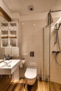 ein Badezimmer mit Toilette, Waschbecken und Dusche in der Unterkunft Cardoner Hotel és Konferenciaközpont in Dobogókő + 65 Fotos