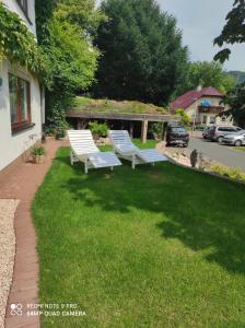 drei Bänke, die im Gras im Hof sitzen in der Unterkunft Ferienwohnung Klein und Fein in Hemfurth-Edersee