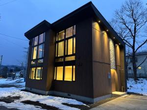 a building with the lights on in the snow at Chalet Infinity by The Hakuba Collection in Hakuba