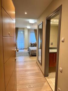 um corredor com um quarto com uma cama e um espelho em Lodge Euphoria Studio em Borovets