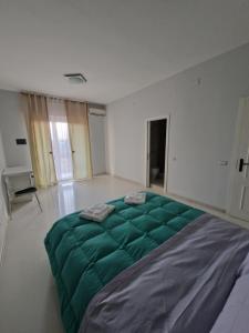 1 cama verde grande en una habitación blanca en Ciao Napoli, en Nápoles