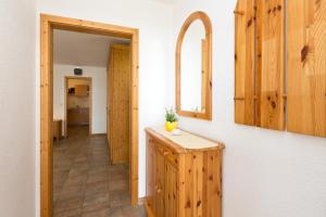 a kitchen with wooden cabinets and a mirror and a hallway at Ferienwohnung Maribell in Jabel