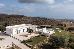 an aerial view of a white house with a hill at Redimeti Country House in Avola