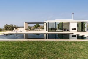 a modern house with a pool and grass at Redimeti Country House in Avola