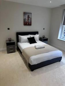 - une chambre avec un grand lit et 2 tables de chevet dans l'établissement Beautiful 3bed3bath Kensington, à Londres