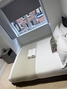 a bed in a room with a window and a bed sidx sidx sidx at Beautiful 3bed3bath Kensington in London