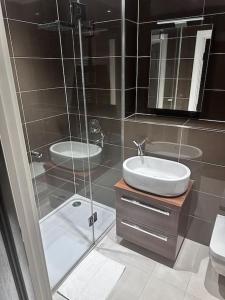 uma casa de banho com uma cabina de duche em vidro e um lavatório. em Beautiful 3bed3bath Kensington em Londres