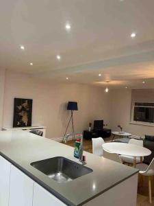 a kitchen with a sink and a living room at Beautiful 3bed3bath Kensington in London