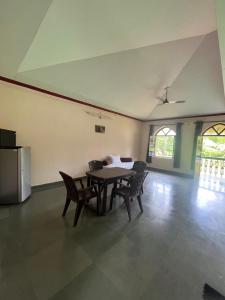 a dining room with a table and chairs and a refrigerator at Green valley jungle resort 