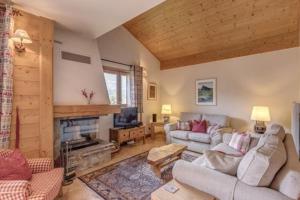 a living room with a couch and a fireplace at Le Chardon Argenté T4 Duplex 4 etoiles - 7 couchages - Parking&Piscine in Samoëns