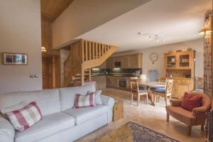 a living room with a white couch and a kitchen at Le Chardon Argenté T4 Duplex 7 couchages - Parking in Samoëns