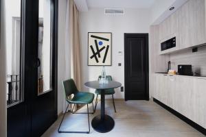 a room with a table and chairs and a kitchen at numa I Luna Apartments in Madrid
