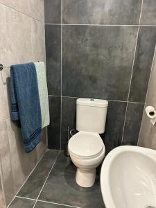 a bathroom with a white toilet and a sink at Le Rosette Residence in Empangeni
