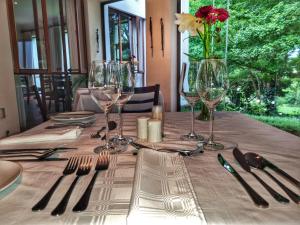 einen Tisch mit Weingläsern und eine Vase mit Blumen in der Unterkunft Budmarsh Country Lodge in Magaliesburg