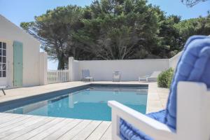 a swimming pool with a chair next to a fence at Le Clos du Pertuis in La Flotte