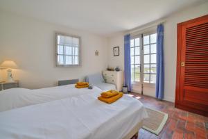 a bedroom with two beds with towels on them at Le Clos du Pertuis in La Flotte