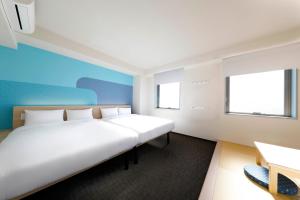 東京にあるHop Inn Tokyo Asakusaの窓2つが備わる客室で、白い大型ベッド1台が付いています。