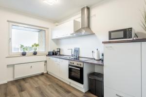 a kitchen with white cabinets and a stove top oven at Luxus Penthouse, Klima, BBQ, Whirlpool in Warendorf