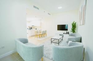 ein Wohnzimmer mit blauen Stühlen und einem Tisch in der Unterkunft Citi home 1BR New Marina Sulafa Tower in Dubai