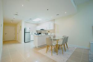 cocina con mesa, sillas y nevera en Citi home 1BR New Marina Sulafa Tower, en Dubái