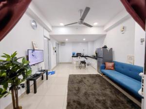 a living room with a blue couch and a tv at SkyHome @ D'Perdana Kota Bharu in Kota Bharu