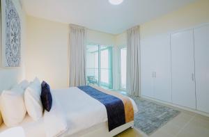 une chambre avec un lit et une grande fenêtre dans l'établissement CitiHome - Contemporary 1BR with Dubai Marina Glimpse, à Dubaï 35 autres photos