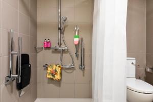 a bathroom with a shower with a toilet at Moxy Glasgow SEC in Glasgow