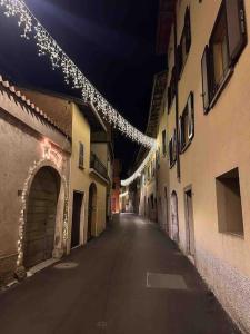 une allée vide avec des lumières de Noël suspendues à des bâtiments dans l'établissement Rancate charme apartment, à Mendrisio