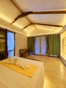 a bedroom with a bed in a room with green curtains at Kawai Duli Bungalows 1 in Duli