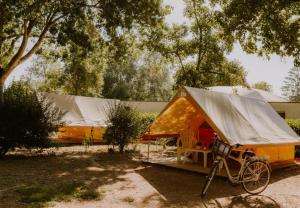 ein Zelt mit einem Fahrrad, das davor geparkt ist in der Unterkunft CAMPING ONLYCAMP LA ROSERAIE in Descartes