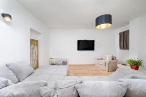 ein Wohnzimmer mit einem weißen Sofa und einem TV in der Unterkunft Villa Fiera by IstriaLux in Svetvinčenat
