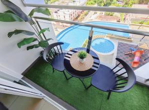 d'un balcon avec une table, des chaises et une piscine. dans l'établissement SkyHome @ D'Perdana Kota Bharu, à Kota Bharu