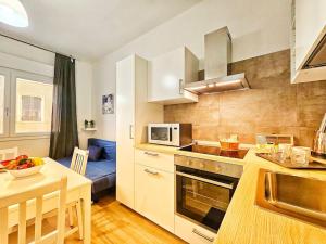 - une cuisine avec une table et une kitchenette dans l'établissement Appartamento a Pirri, via E. Toti. Cagliari. Rosas Rooms., à Cagliari