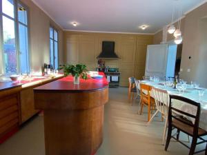 a kitchen with a bar with a table in it at Maison familiale éco rénovée in Ault