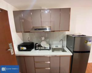 a small kitchen with a sink and a refrigerator at Studio Tower by KR in Baguio +5 photos