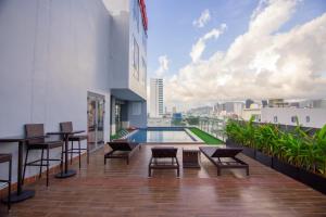 a balcony with a swimming pool on top of a building at Quoc Cuong Hotel & Apartment Danang by Haviland in Da Nang +100 photos