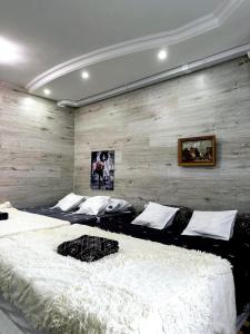 twee grote bedden in een kamer met houten wanden bij Smart Apartment in Chişinău