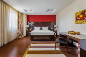 Una habitación de hotel con una cama y un escritorio y un escritorio. en Darhan Boutique Hotel, en Tashkent