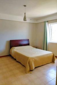 ein Schlafzimmer mit einem Bett in einem Zimmer mit einem Fenster in der Unterkunft Appartement calme à Calodyne proche de la plage in Calodyne