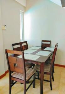 einen Esstisch mit 4 Stühlen, einem Tisch, einem Tisch und einem Stuhl in der Unterkunft Appartement calme à Calodyne proche de la plage in Calodyne