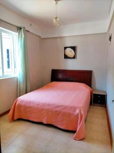 Schlafzimmer mit einem roten Bett und einem Fenster in der Unterkunft Appartement calme à Calodyne proche de la plage in Calodyne