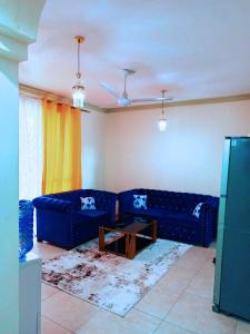 a living room with a blue couch and a table at Bamburi 2 bedroom Luxury homes in Bamburi