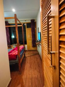 1 dormitorio con litera y escritorio con TV en Kross Vindz, en Mukteshwar
