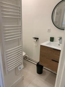 a white bathroom with a sink and a mirror at Superbe duplex hypercentre dans une rue piétonne in Limoges