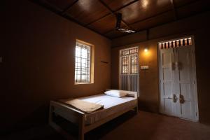 a bedroom with a bed and a window and a door at Wild Mist Homestay in Rānī